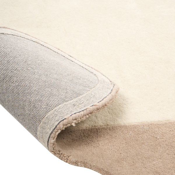 Beigefarbener Teppich mit weichem Flor, stabiler Textil-Rückseite und sauber eingefasster Kante in der Detailansicht.