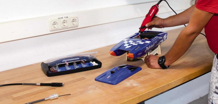 Einhell Multifunktionswerkzeug wird für Arbeiten im Modellbau an einem Boot auf einer Werkbank verwendet.