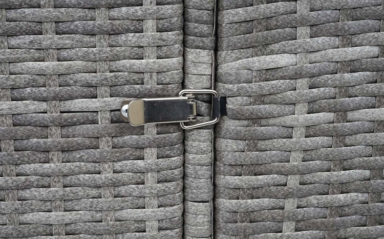 Detailansicht eines Möbelstücks mit einem Verschluss aus Metall an einer geflochtenen Oberfläche.