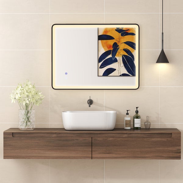 Modernes, helles Badezimmer mit beleuchtetem Spiegel, weißem Keramikwaschbecken auf einem Holzwaschtischunterschrank und schwarzer Wandarmatur.