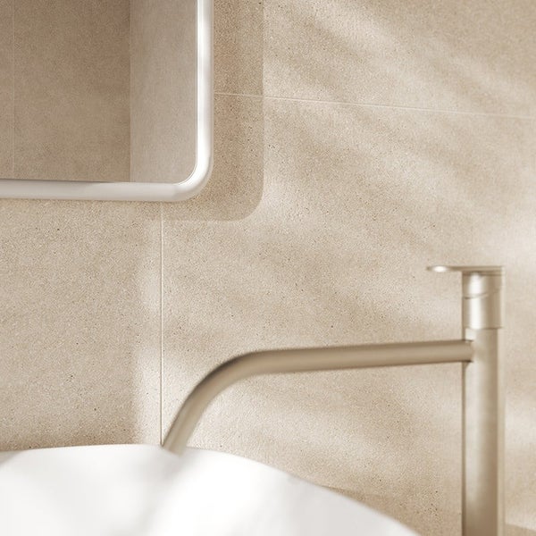 Badezimmer mit hellen strukturierten Fliesen im Steinoptik Design, Waschbecken mit moderner Armatur und Spiegel.