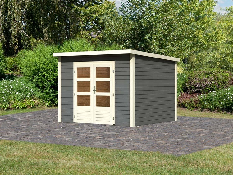 Modernes Gartenhaus aus Holz mit Pultdach, Doppeltür mit Fenstern und dunklen Wänden auf gepflasterter Gartenfläche.