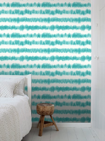 Schlafzimmer mit Bett und Wandtapete mit Streifenmuster