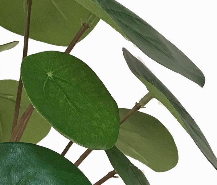 Künstliche Palme mit grünen Wedeln im schwarzen Kunststofftopf.