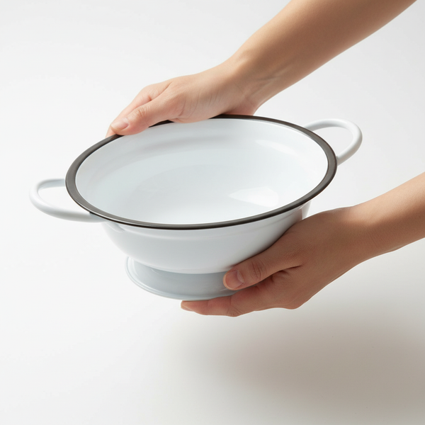 Weiße Emaille-Schüssel mit zwei Griffen und dunklem Rand.