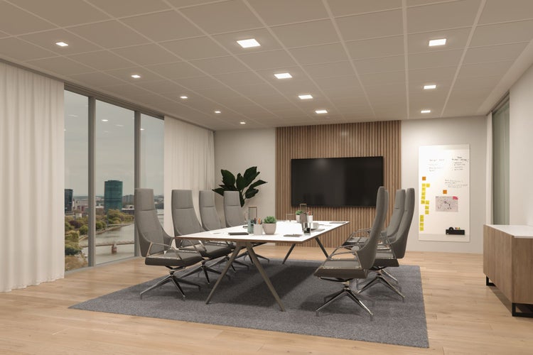 Moderner, hell erleuchteter Konferenzraum mit quadratischen LED-Einbaupaneelen in der Rasterdecke, großem Besprechungstisch und Holzboden.