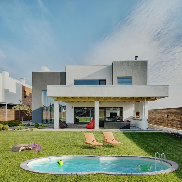 Garten mit Pool, Liegestühlen und modernem Haus