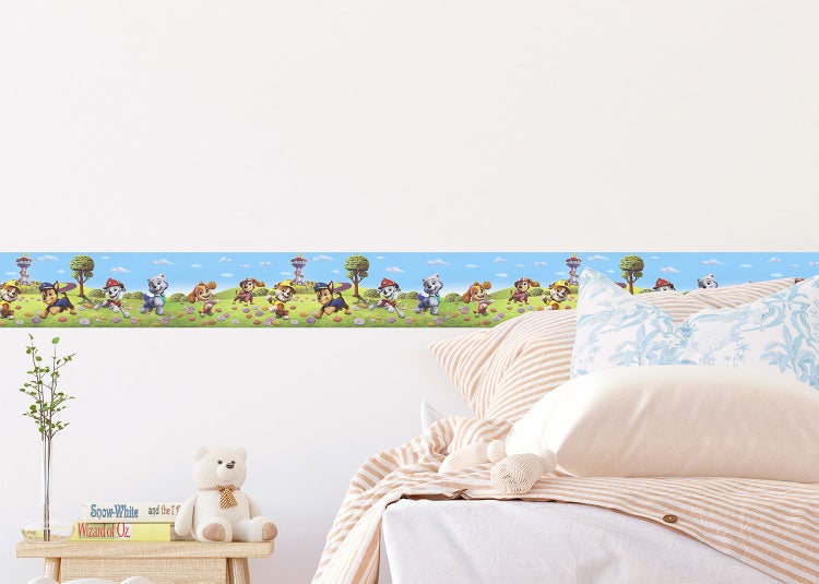 Tapetenbordüre mit Paw Patrol Motiven im Kinderzimmer über einem Bett.
