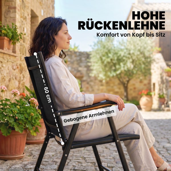 Eine Frau sitzt in einem schwarzen Gartenstuhl mit einer hohen Rückenlehne von 60 Zentimetern und gebogenen Armlehnen im Außenbereich.