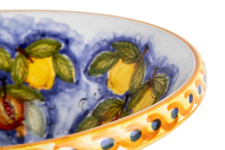 Keramikschale mit handgemaltem Zitronen- und Granatapfel-Dekor sowie blauem Innenmuster.