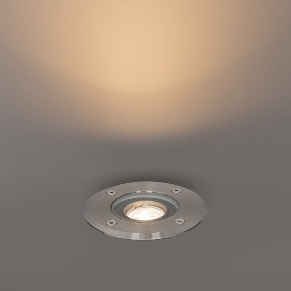 Runder Bodenstrahler aus Edelstahl mit warmem Lichtschein nach oben gerichtet.