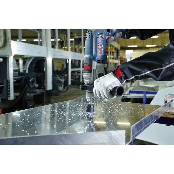 Handwerker bohrt mit einer Bohrmaschine ein Loch in ein Metallstück. Bosch Logo.