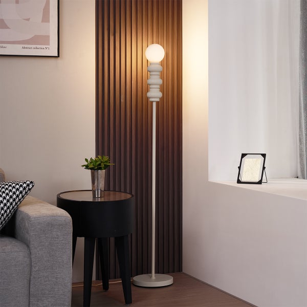 Wohnzimmer mit Stehlampe, Beistelltisch und Dekoration