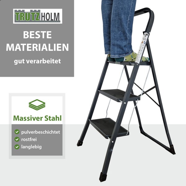 Eine Trutzholm Haushaltsleiter aus Stahl mit drei Stufen und Sicherheitsbügel, auf der eine Person steht.