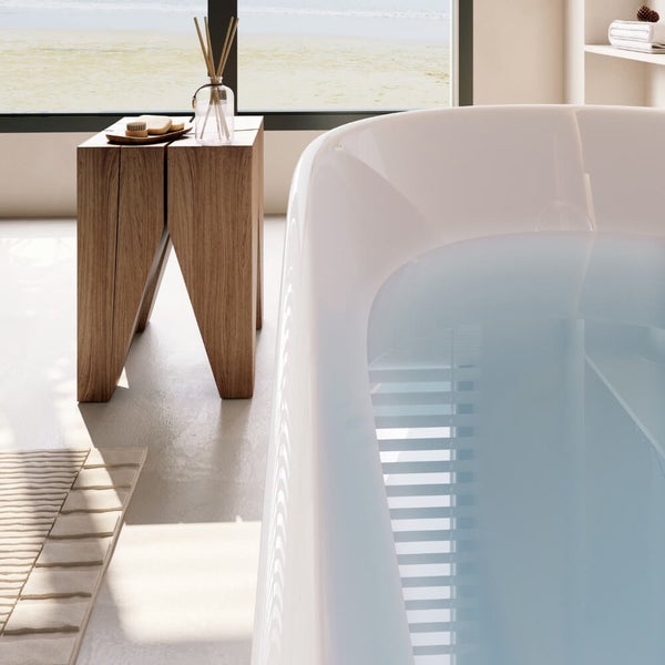Moderne freistehende Badewanne in einem hellen Badezimmer mit hölzernem Beistelltisch und Blick auf die Natur durch ein großes Fenster.