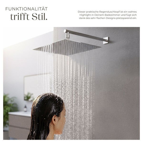 Quadratischer, flacher Regenduschkopf aus Edelstahl an einer Wand im modernen Badezimmer mit herabfallendem Wasser auf eine Person.