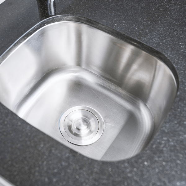 Einbau-Küchenspüle aus Edelstahl als Unterbau-Variante in einer Arbeitsplatte mit rundem Abfluss.