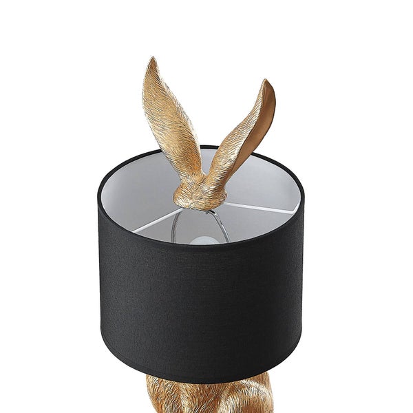 Nahaufnahme einer Tischleuchte mit Hasen-Design, goldfarbenen Ohren und einem schwarzen Stoff-Lampenschirm.