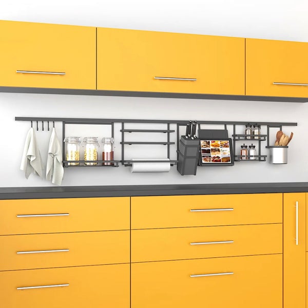 Moderne Küche mit gelben Schränken und einem schwarzen Küchen-Relingsystem an der Wand inklusive Zubehör wie Messerblock und Tablethalter.