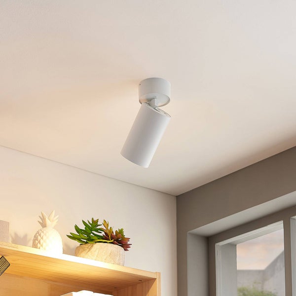 Zylinderförmiger Deckenstrahler in Weiß, montiert an einer hellen Decke über einem Holzregal mit Dekoration.