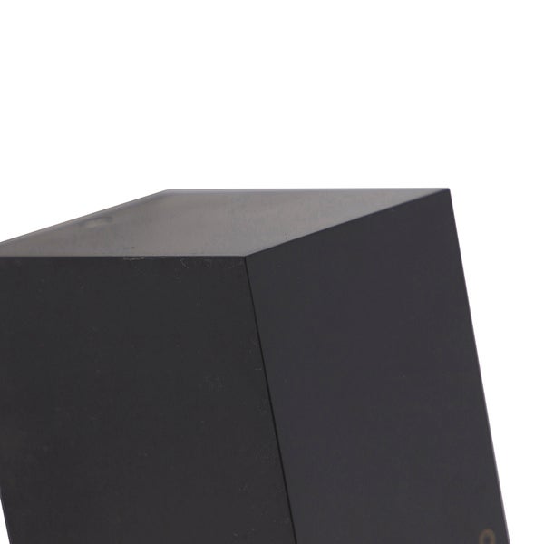Nahaufnahme einer schwarzen Wandleuchte in Würfelform aus Metall.