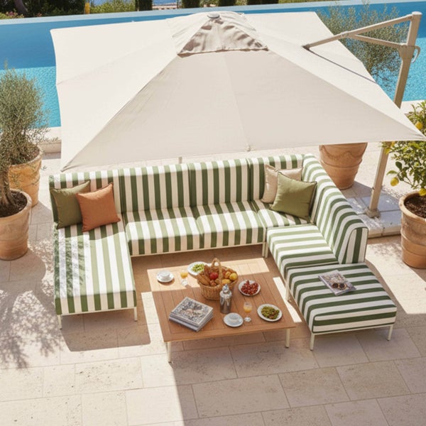 Moderne Gartenlounge mit grün-weiß gestreifter Polsterung, quadratischem Holztisch und großem Ampelschirm auf einer Terrasse am Pool.