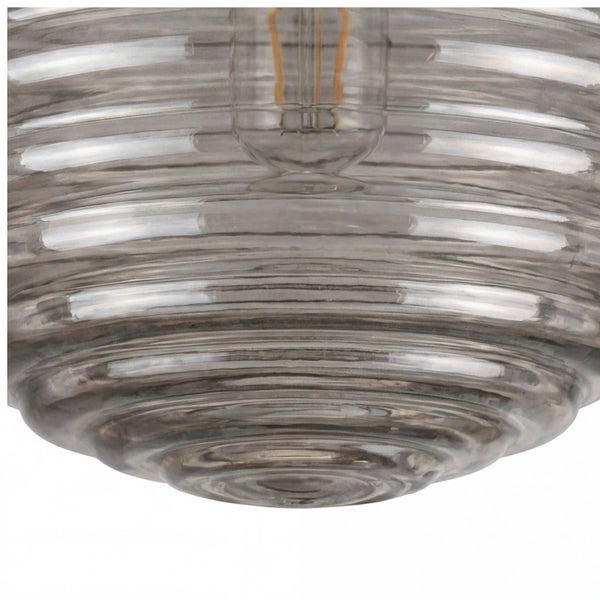 Nahaufnahme eines runden Lampenschirms aus Glas mit horizontaler Rillenstruktur und sichtbarem Leuchtmittel im Inneren.