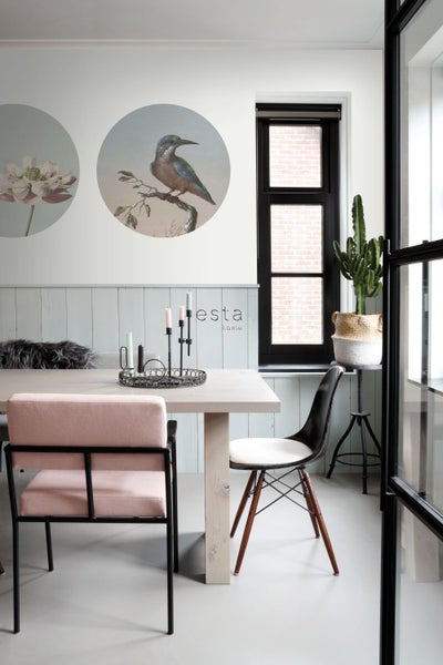 Heller Essbereich mit Esstisch, Stühlen, Wandbildern und Kaktus