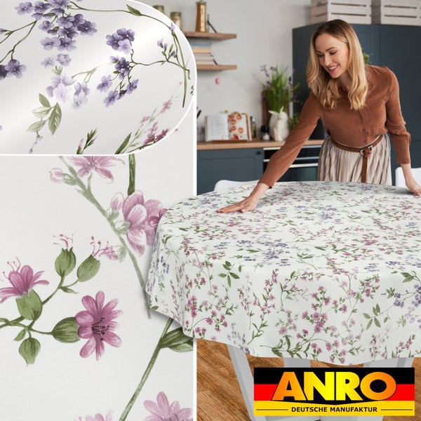 Eine Frau breitet eine runde Tischdecke mit Blumenmuster in einer modernen Küche aus. Inklusive Detailansicht des Musters und ANRO Logo.