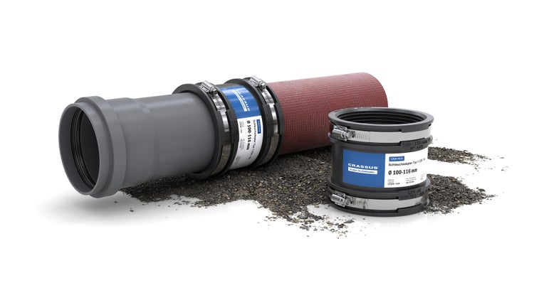 Crassus Schlauchadapter Typ 1 CDC 100, Durchmesser 100 bis 116 Millimeter, Verbindung von einem grauen und einem roten Rohr auf Kies.