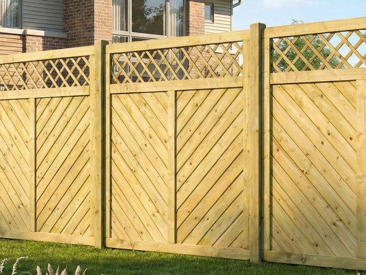 Holzzaun mit Rautenmuster als oberem Abschluss im Garten.