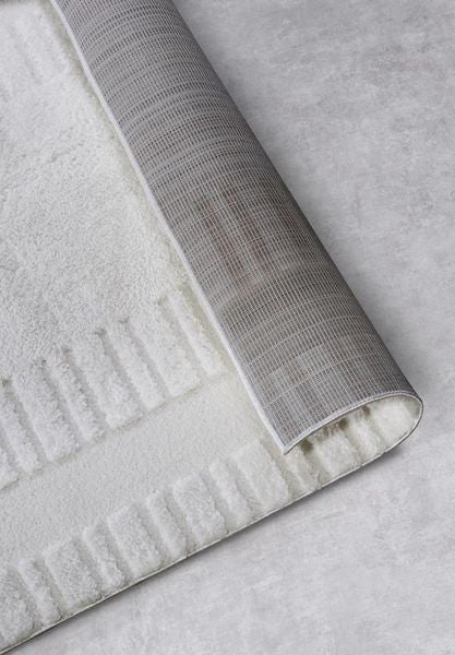 Innenraum mit einem gemusterten Teppich, einem Schaukelstuhl und einem großen Fenster