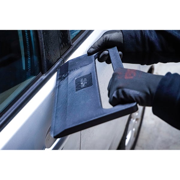 Person mit Handschuhen benutzt ein Werkzeug an einem Auto