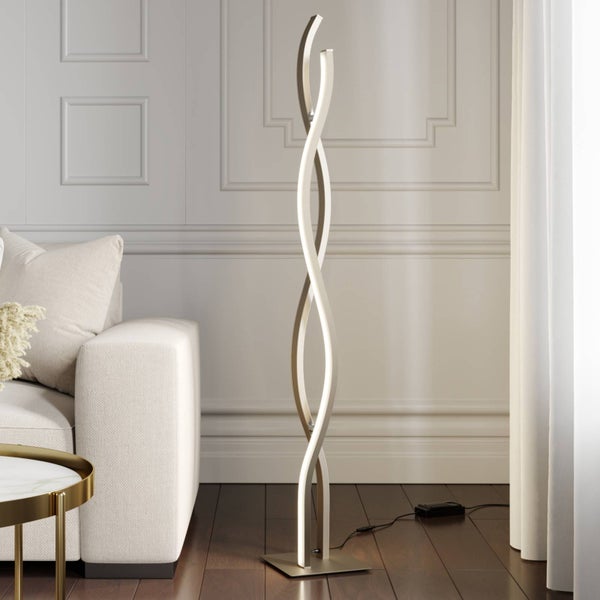 Moderne LED-Stehleuchte in Wellenform mit zwei ineinander verschlungenen Leuchtelementen in einem hellen Wohnzimmer neben einem Sofa.
