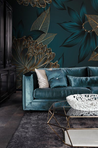 Wohnzimmer mit blauem Sofa, Couchtisch und floraler Tapete