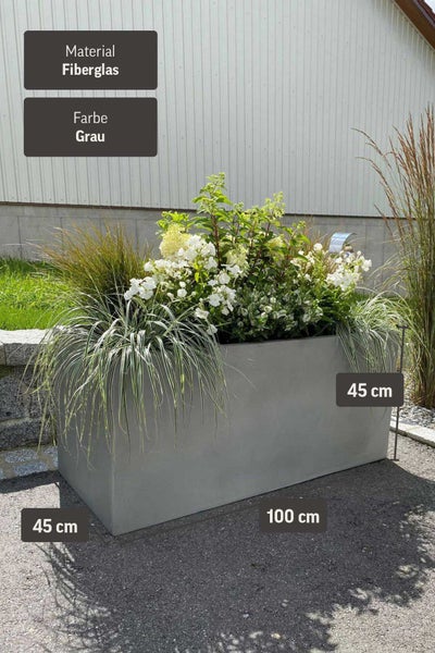 Rechteckiger Pflanztrog aus Fiberglas in Grau, bepflanzt mit Hortensien und Gräsern, Maße 100 mal 45 mal 45 Zentimeter.