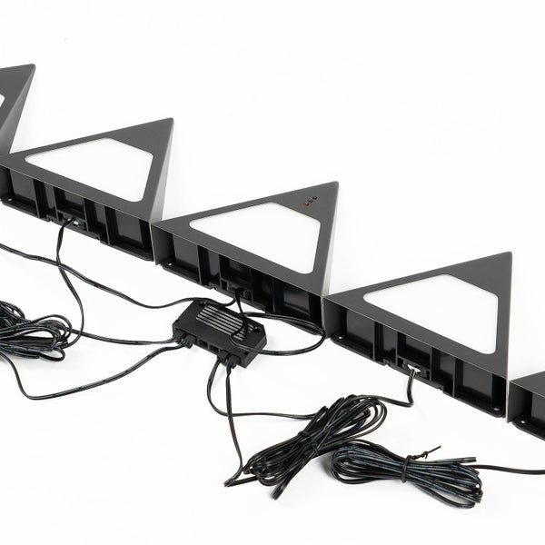 Set aus dreieckigen LED-Möbelleuchten mit Verbindungskabeln und einer zentralen Verteilerbox.