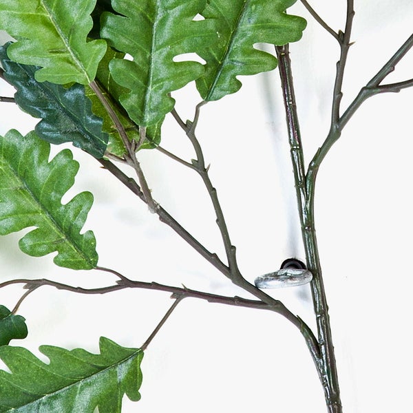 Künstlicher Eichenzweig mit grünen Blättern und Metallöse zur Befestigung.