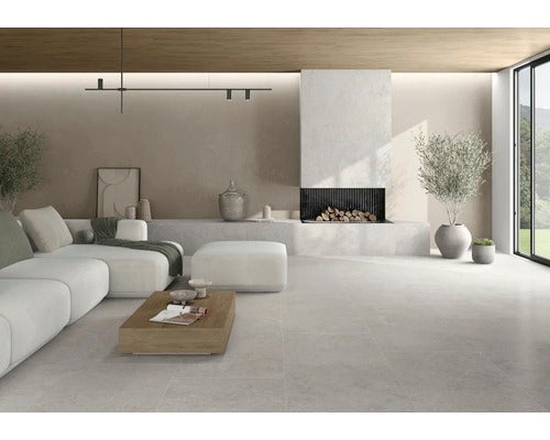 Heller Wohnraum mit Couch, Kamin und Fliesenboden