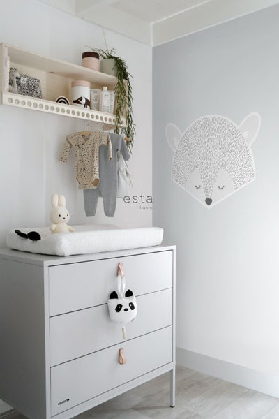 Babyzimmer mit Wickelkommode, Wandregal und dekorativer Wandgestaltung.