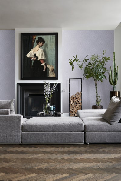 Wohnzimmer mit grauer modularen Couch, Kamin, Dekoration und einem Gemälde an der Wand.