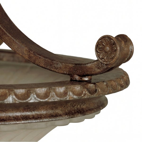 Detailaufnahme eines rustikalen Metallarms einer Leuchte mit Blumenornament und dekorativem Rand über einem Glasschirm.
