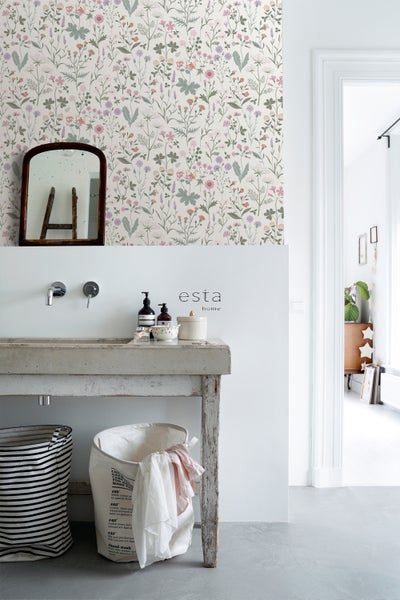 Badezimmer mit Blumentapete, Waschbecken und Spiegel