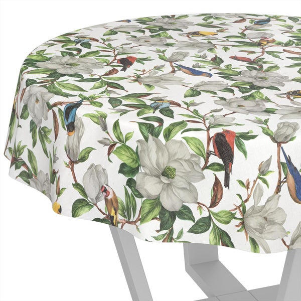 Runde Tischdecke mit Magnolienblüten, grünen Blättern und bunten Vögeln.