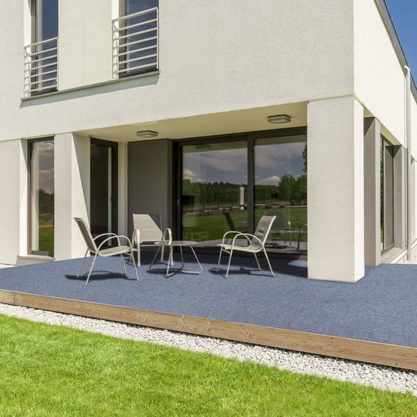 Terrasse mit Terrassenteppich, Gartenmöbeln und angrenzendem Rasen