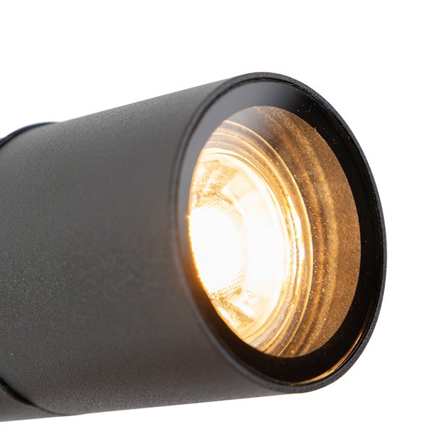 Nahaufnahme eines zylindrischen LED-Strahlers in Schwarz mit eingeschaltetem warmweißem Licht.