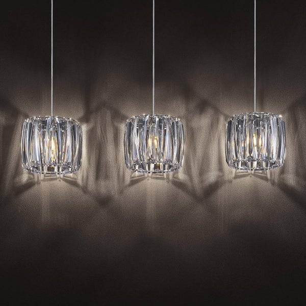 Dreiflammige Pendelleuchte mit zylindrischen Schirmen aus facettiertem Kristallglas für dekorative Lichteffekte an der Wand.