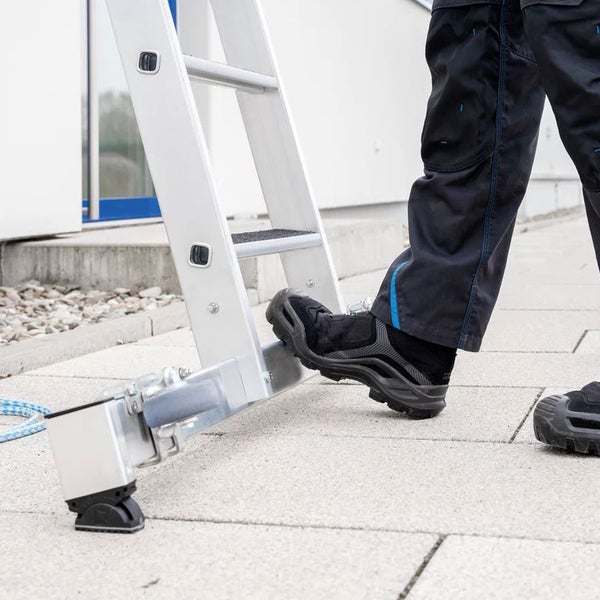 Detailansicht einer Aluminiumleiter mit einer Person, die auf einer Stufe steht