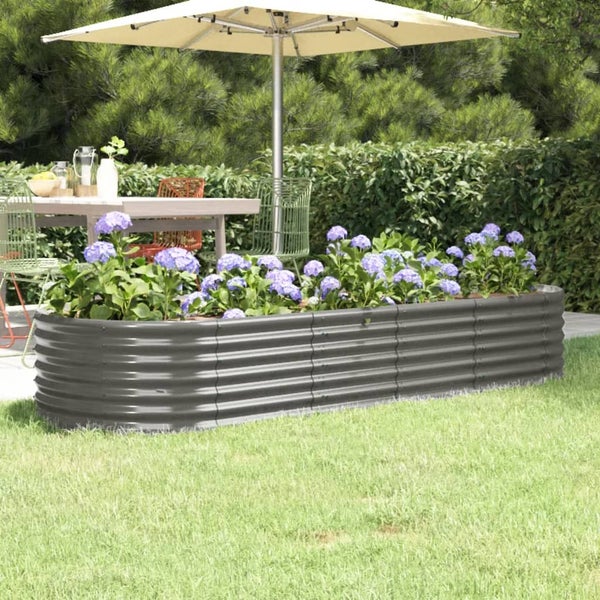 Hochbeet aus Metall mit blühenden Pflanzen im Garten.
