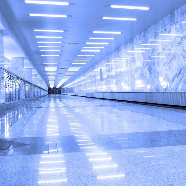 Blick in einen beleuchteten Flur mit Deckenleuchten und Marmorwänden